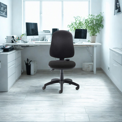 Black office chair in a bright, modern office setting with white desks and computer monitors.