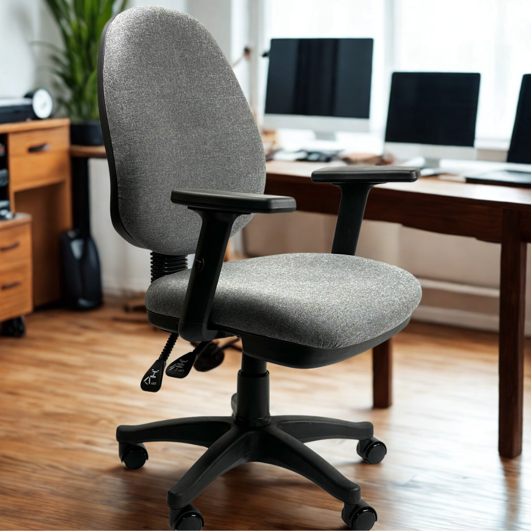 Gray office chair in a home office setting with a desk and computer monitors.