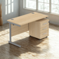 Wooden office desk with drawers in a bright room with large windows.