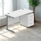 White office desk with three drawers in a bright room with a plant.