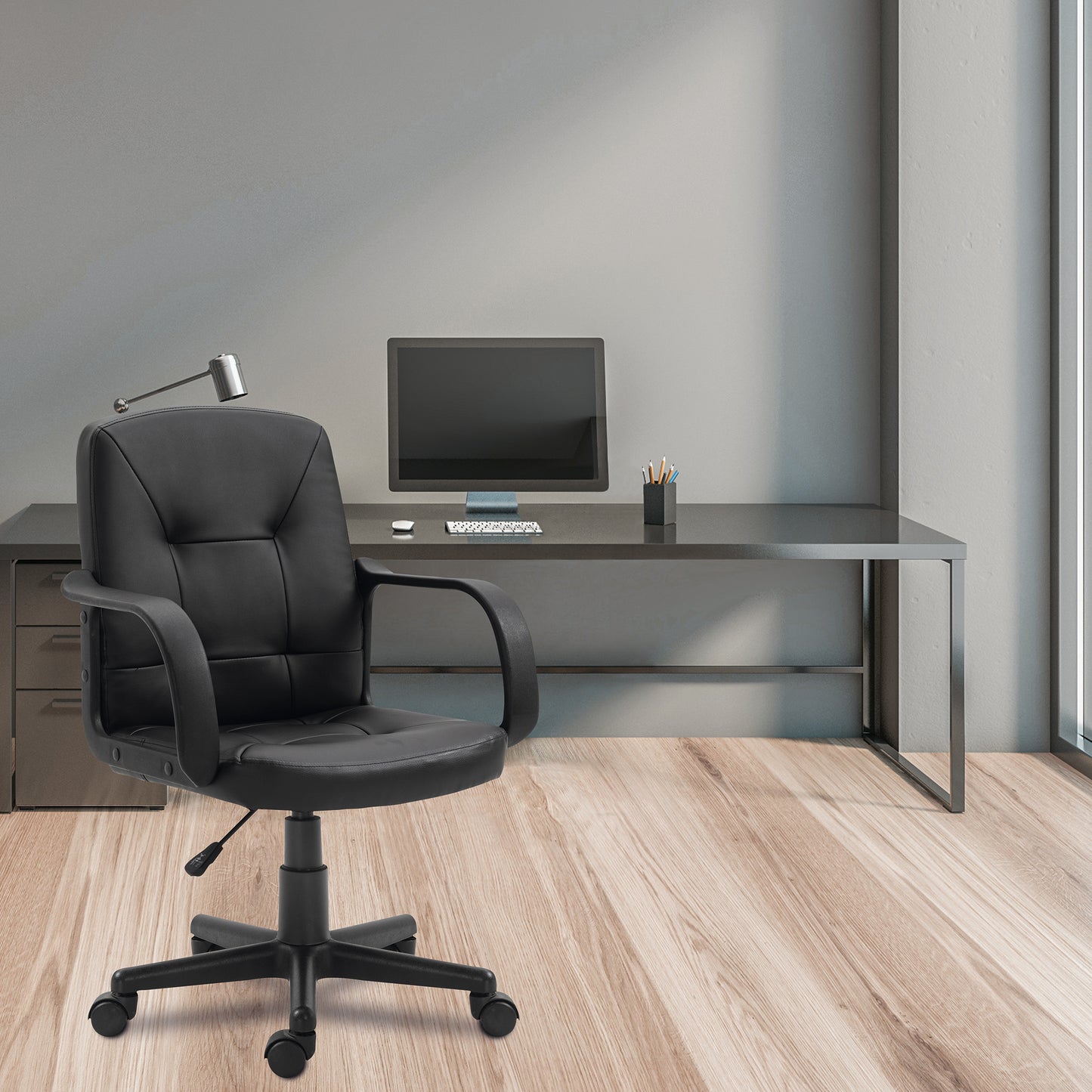 Modern office setup with black office chair and desk against a gray wall.