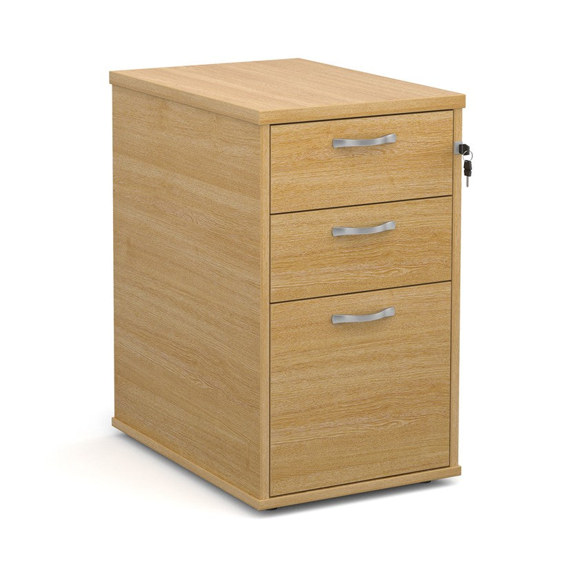 A wooden mobile pedestal with three drawers, lockable with silver handles, in an office setting.