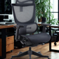 Black office chair in an office setting with a desk and plants.