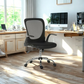 Black office chair in a bright home office with wooden desk and windows.