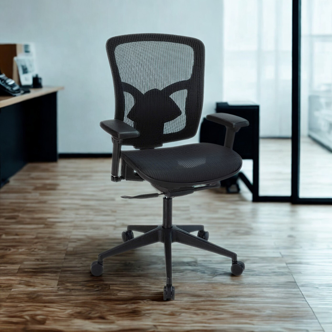 Black office chair in an office setting with a desk and window in the background.