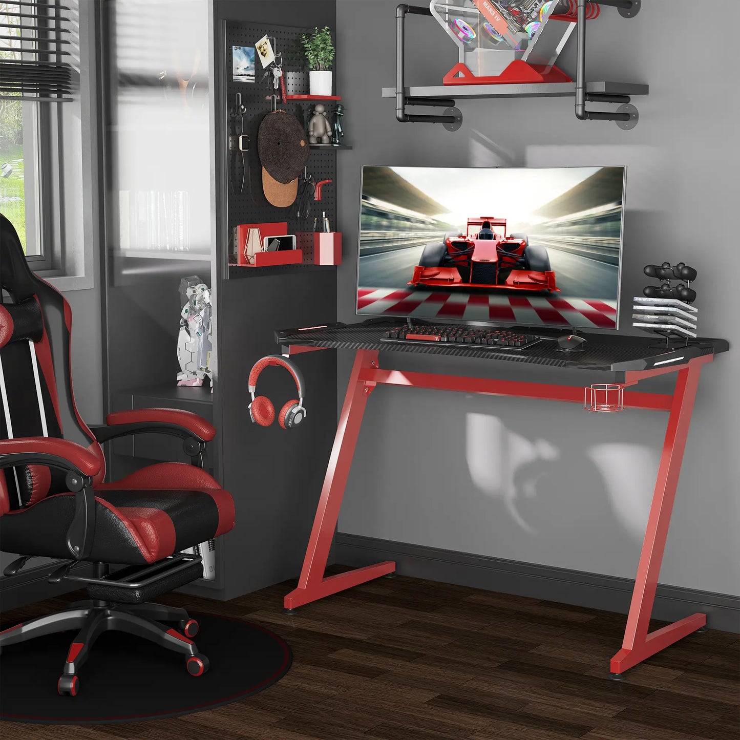 A gaming desk with a carbon fibre design in black and red, featuring a steel frame, a large tabletop, and accessories such as a monitor, keyboard, and headphones.