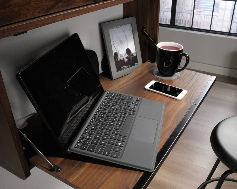 Hampstead Park Wall Desk shown open and in use in an office setting with a laptop and a cup of fruit tea.