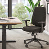 Black office chair in an office setting with a desk and large windows.