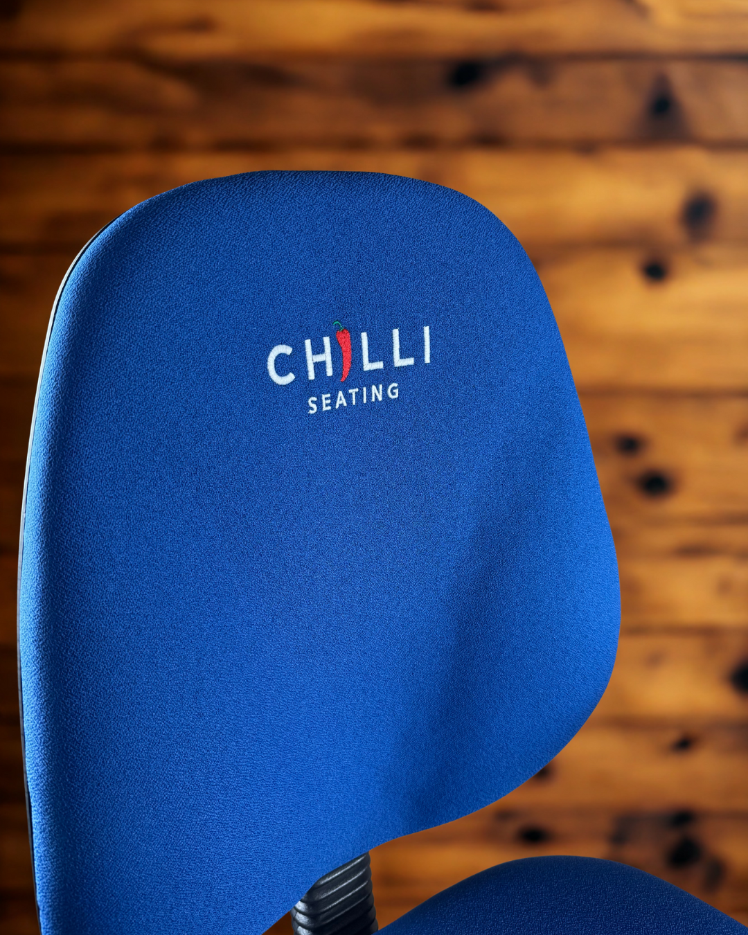 Blue chair with 'Chilli Seating' logo on a wooden floor background