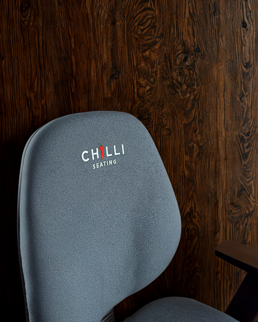 Blue office chair with 'Chilli Seating' logo against a wooden wall.