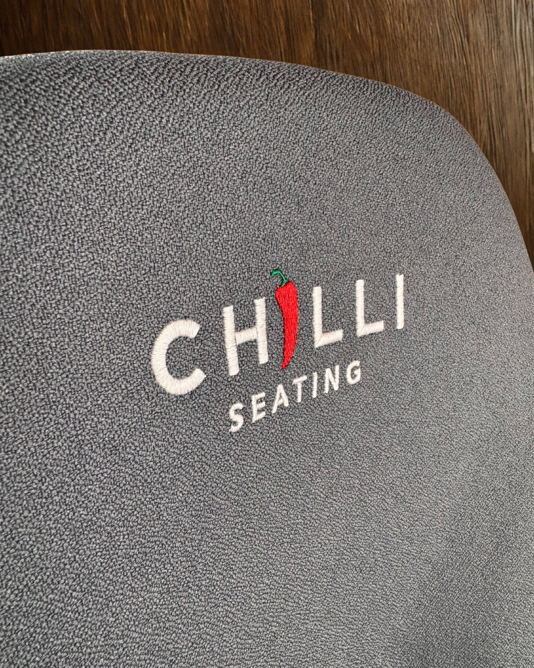 Blue chair with 'Chilli Seating' logo on a wooden floor background