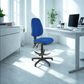 Blue office chair in a bright, modern office setting with a desk and computer.