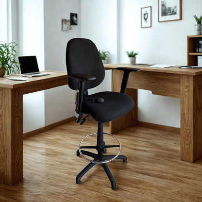 Black office chair in front of a wooden desk with a laptop in a home office setting.