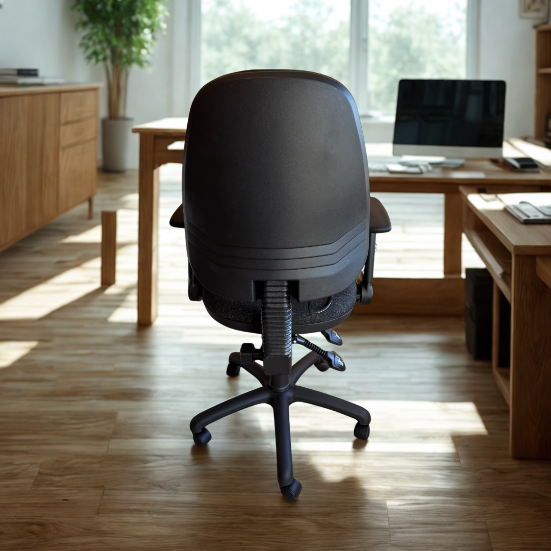 Black office chair in a bright room with wooden furniture and large windows.