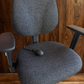 Gray office chair against a wooden wall