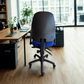 Office chair in an office setting with a desk and large windows.