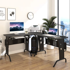 An L-shaped corner desk with a black finish, featuring a CPU rack and a slide-out keyboard tray, placed in a room with a large window and various decorations.