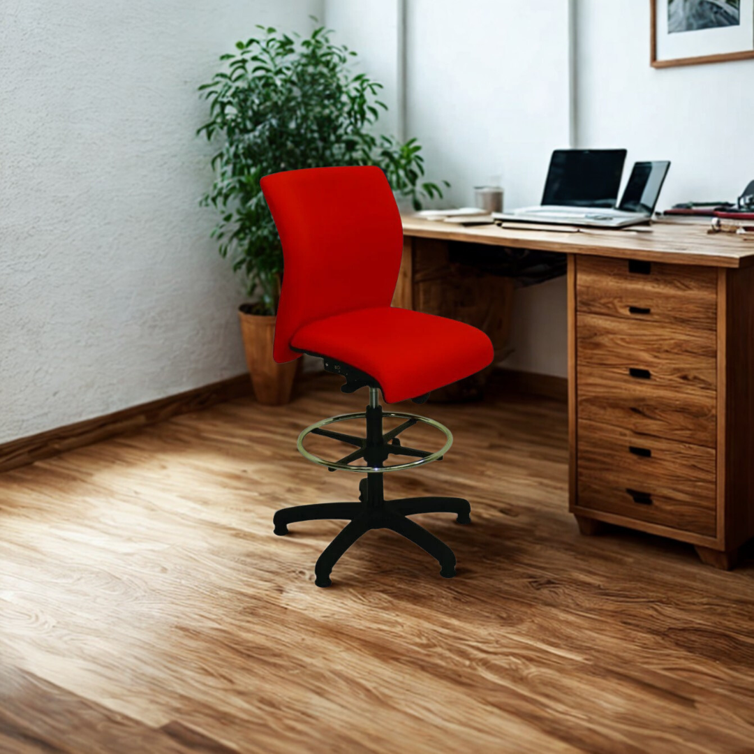 Red office chair in front of a wooden desk with a laptop and plant in a home office setting.