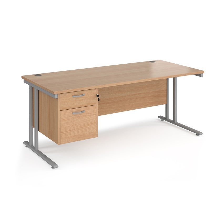 Rectangular office desk with a cantilever frame and a beige two-drawer fixed pedestal. The desk has a melamine finish and is pictured against a white background.
