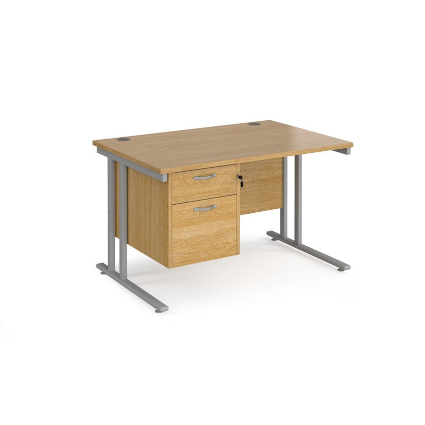 Rectangular office desk with a cantilever frame and a beige two-drawer fixed pedestal. The desk has a melamine finish and is pictured against a white background.
