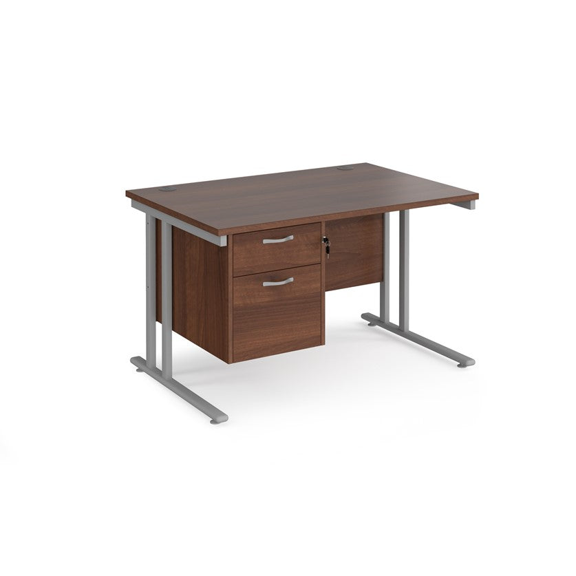 Rectangular office desk with a cantilever frame and a beige two-drawer fixed pedestal. The desk has a melamine finish and is pictured against a white background.
