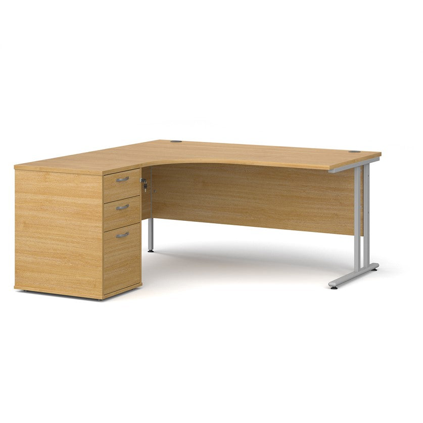 A left-hand corner desk with a cantilever frame and a beige melamine desktop, featuring a pedestal with two drawers.
