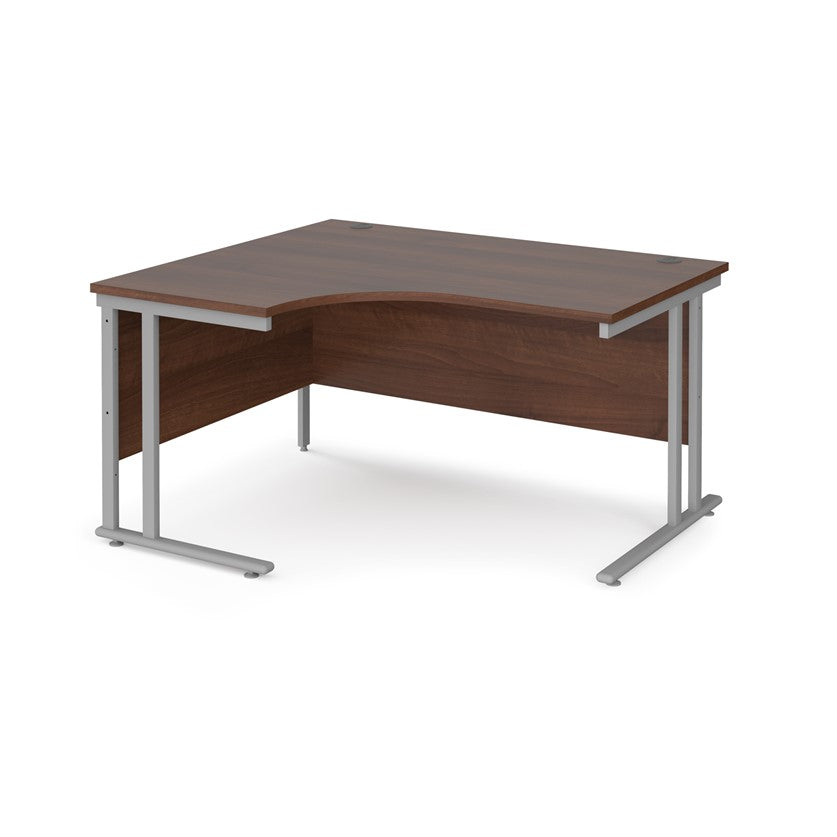 A left hand desk in walnut finish with grey metal legs.