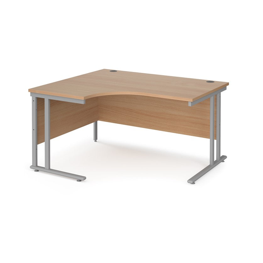 A left hand ergonomic desk with a cantilever frame made of metal and a wooden desktop, positioned against a white background.