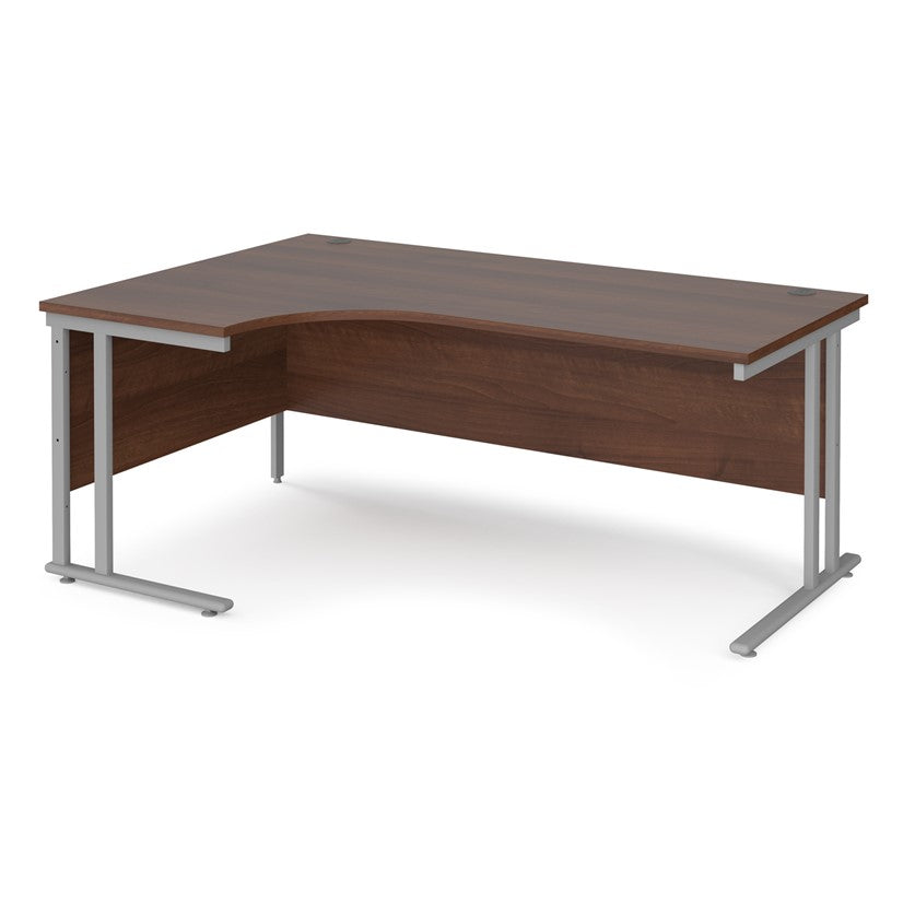 A left hand desk in walnut finish with grey metal legs.