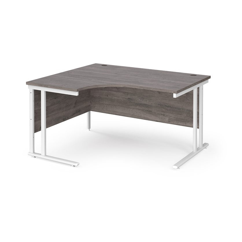 A left hand ergonomic desk with a cantilever frame made of metal and a wooden desktop, positioned against a white background.
