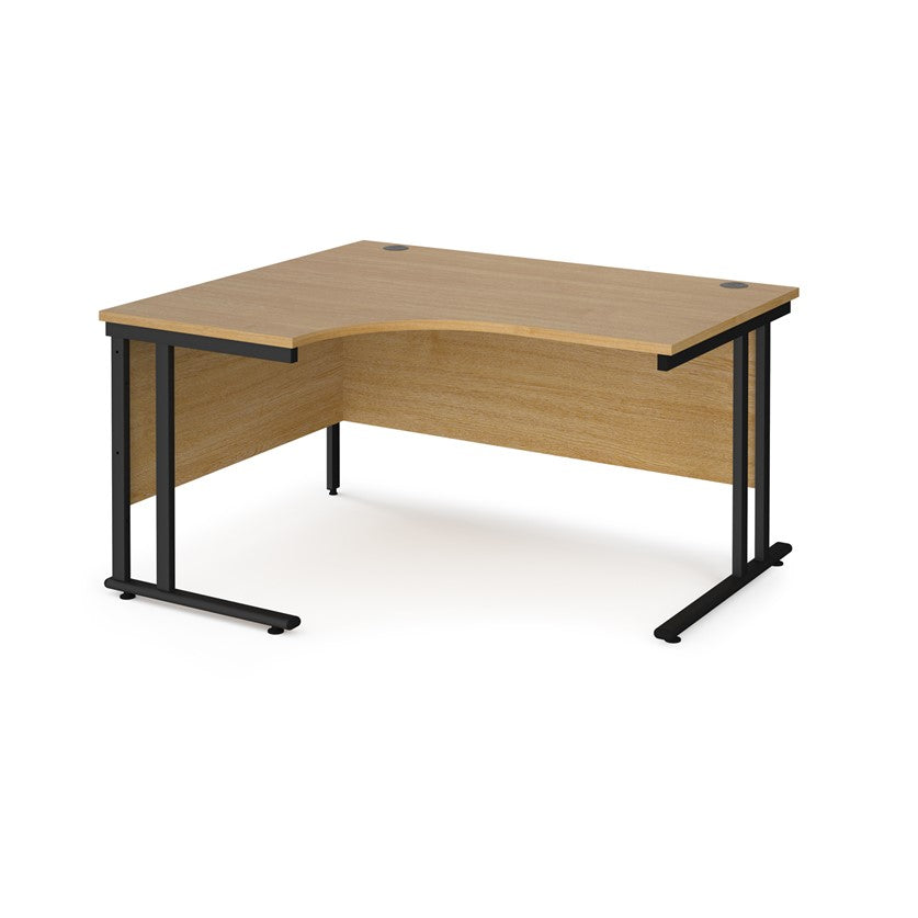 A left hand ergonomic desk with a cantilever frame made of metal and a wooden desktop, positioned against a white background.