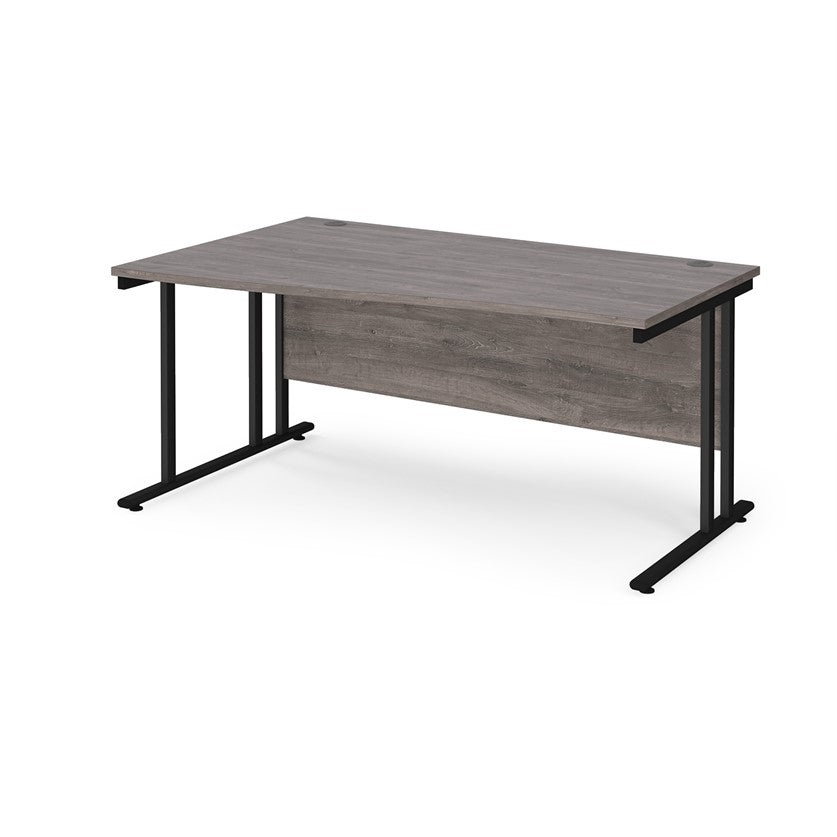 A rectangular office desk with a grey melamine tabletop and black cantilever metal legs.
