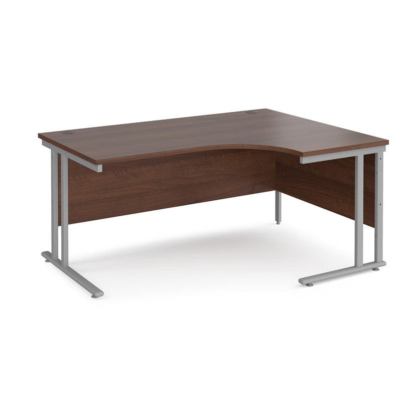 A right-hand ergonomic desk with a walnut melamine tabletop and cantilever metal frame.
