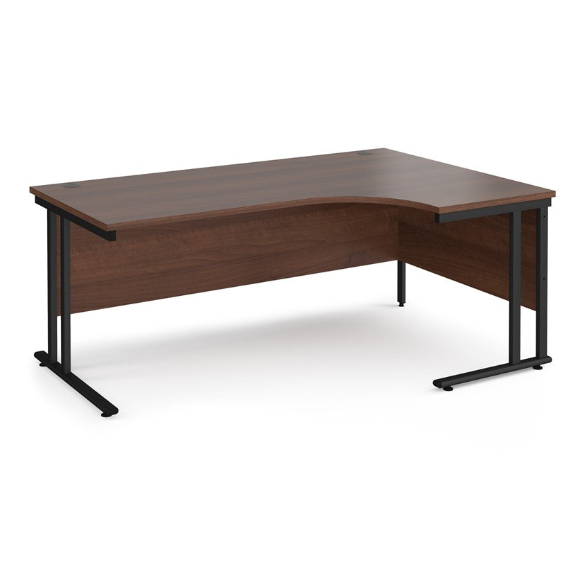 A right-hand ergonomic desk with a walnut melamine tabletop and black cantilever metal frame.