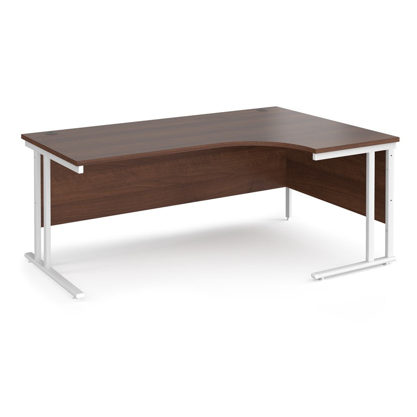 A right-hand ergonomic desk with a walnut melamine tabletop and white cantilever metal frame.
