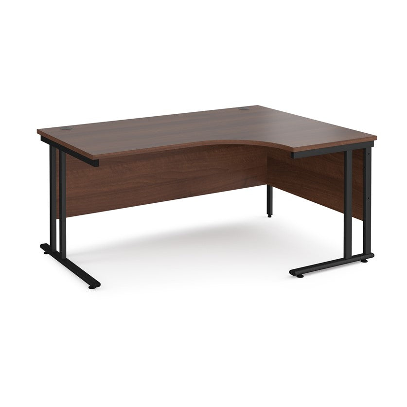 A right-hand ergonomic desk with a walnut melamine tabletop and black cantilever metal frame.