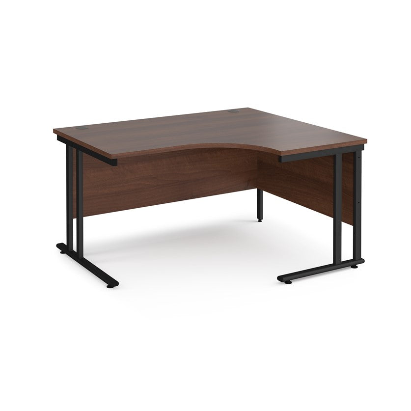 A right-hand ergonomic desk with a walnut melamine tabletop and black cantilever metal frame.