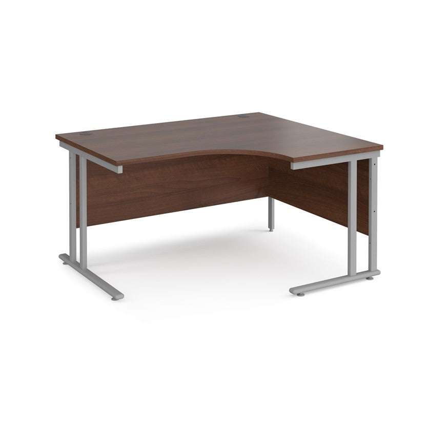 A right-hand ergonomic desk with a walnut melamine tabletop and grey cantilever metal frame.