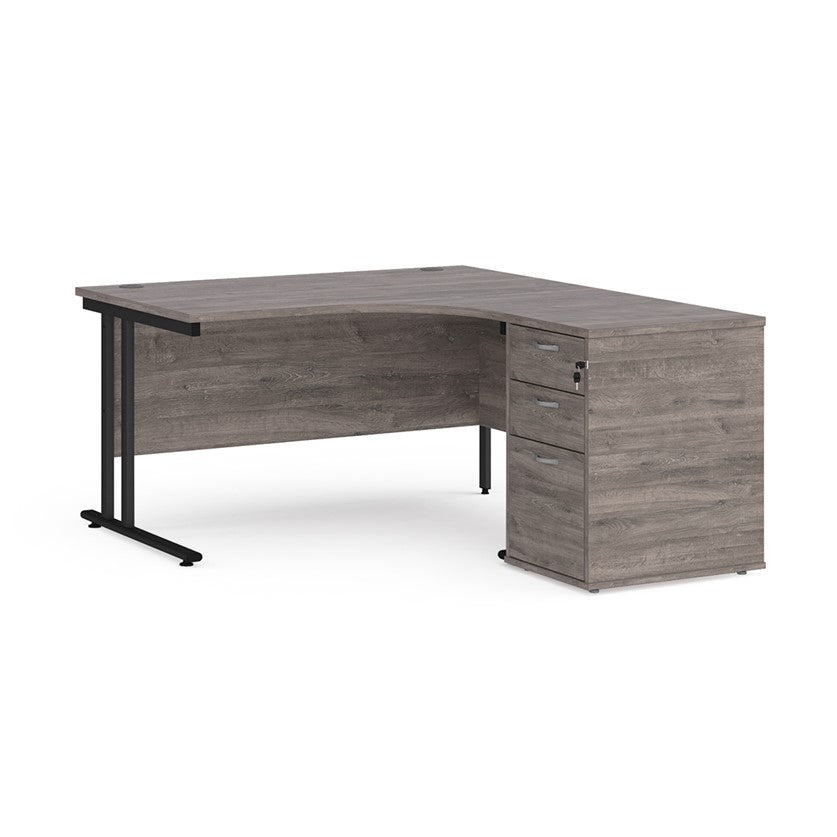 A right-hand configurations office desk with a pedestal storage unit, in a grey wood finish with a cantilever frame.