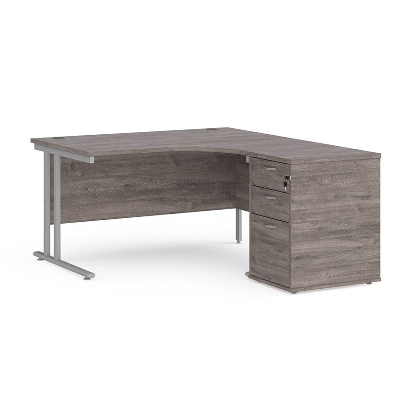 A right-hand configurations office desk with a pedestal storage unit, in a grey wood finish with a silver cantilever frame.