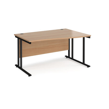 A rectangular office desk with a beige melamine tabletop and black cantilever metal legs.