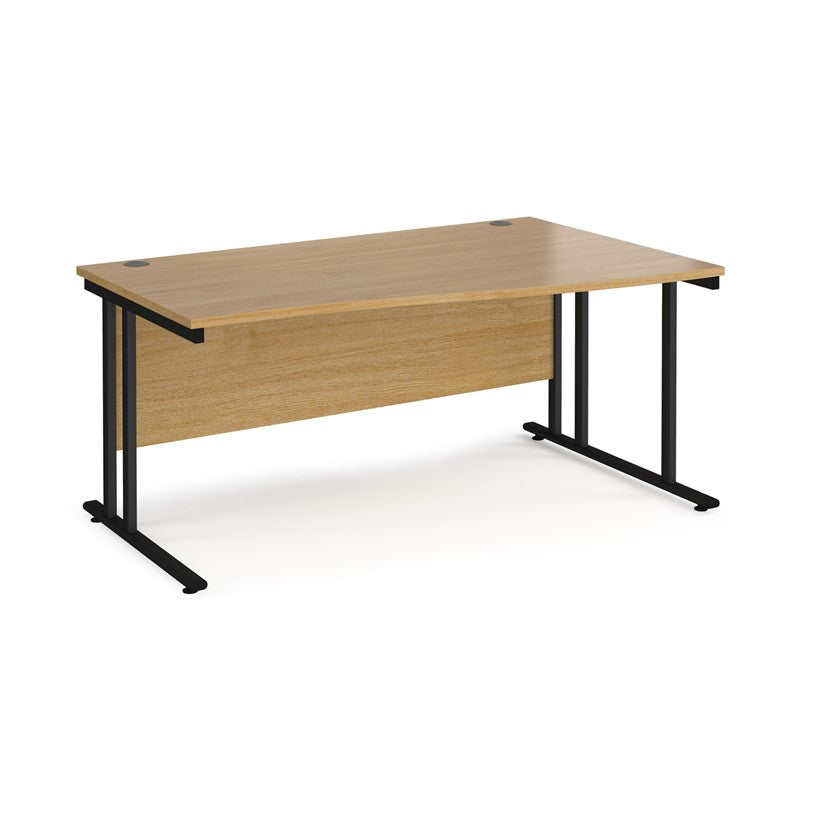 A rectangular office desk with a beige melamine tabletop and black cantilever metal legs.
