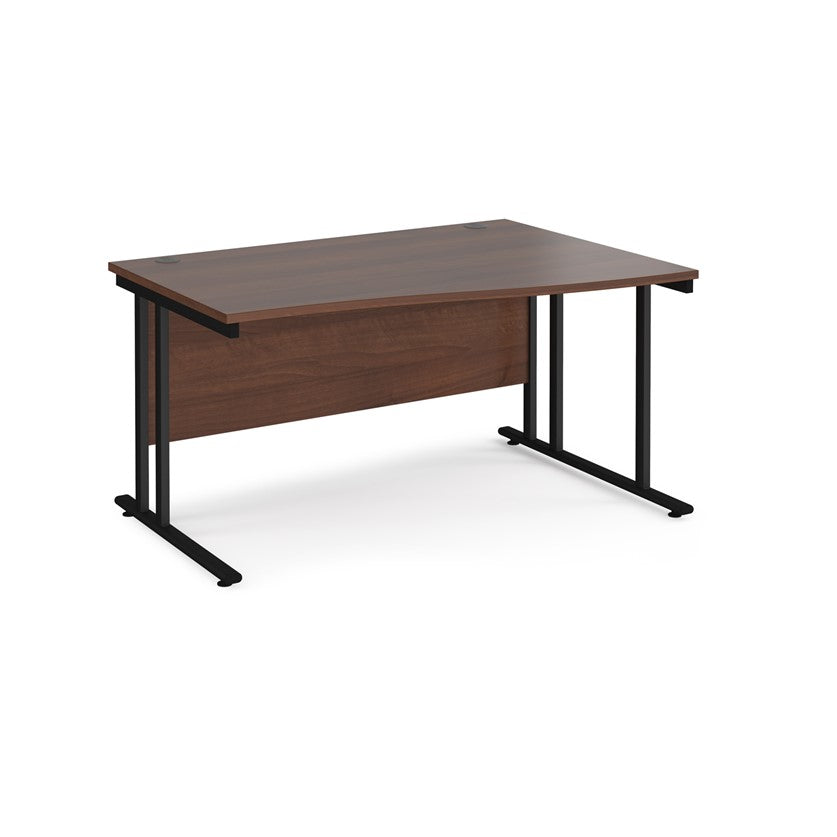 A rectangular office desk with a walnut melamine tabletop and black cantilever metal legs.