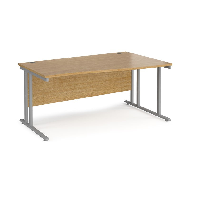 A rectangular office desk with a beige melamine tabletop and grey cantilever metal legs.
