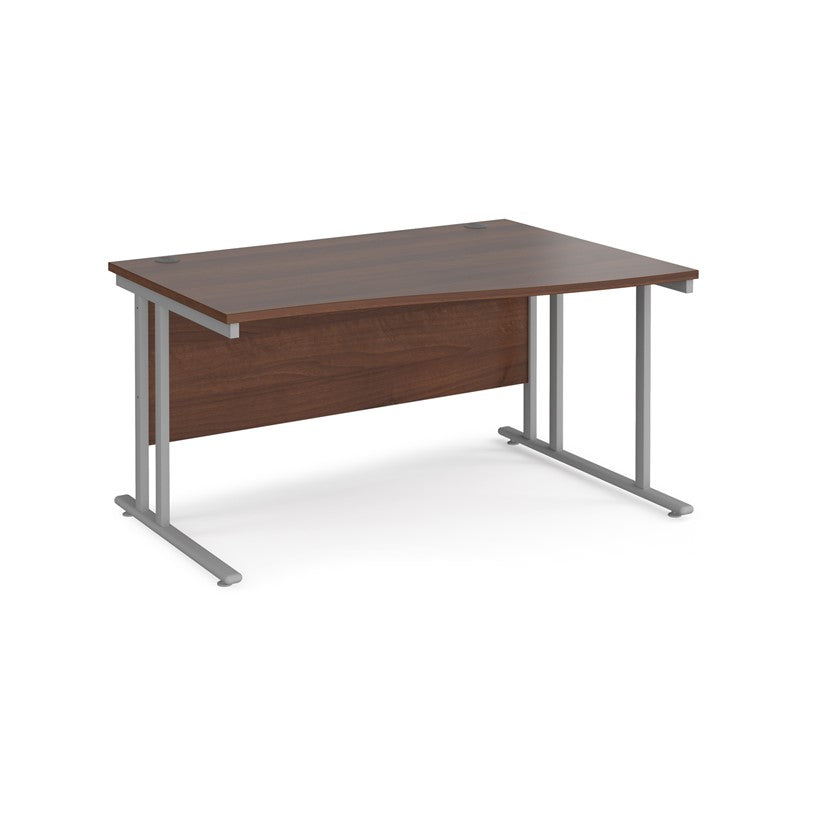 A rectangular office desk with a walnut melamine tabletop and grey cantilever metal legs.
