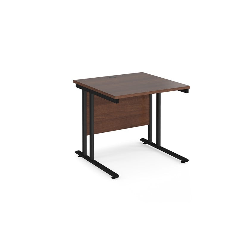 A rectangular office desk with a black cantilever frame and melamine desktop, with one cable access port visible.