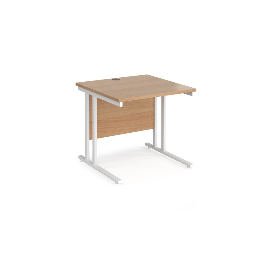 A rectangular office desk with cantilever frame and melamine desktop, with one cable access port visible.