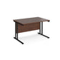 A walnut desk with a black cantilever frame.