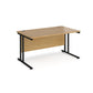 An oak desk with a black cnatilever frame.