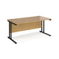 An oak desk with a black cantilever frame. 